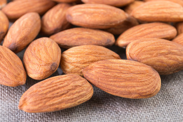 Almond nuts background closeup. Organic food rustic. Angle view.