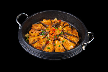 chinese fried fish with spicy seasonings on a black isolated background