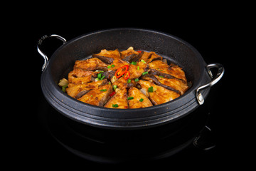 chinese fried fish with spicy seasonings on a black isolated background