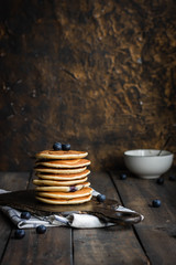 ricotta pancakes with blueberries on a dark wooden background