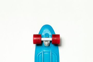 Skateboard cruiser with blue deck and red wheels on isolated white background, top view with copy-space. Concept of sport lifestyle, culture, leisure, hobby, alternative transport