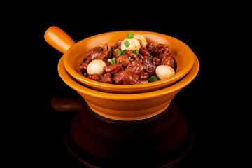 spicy meat with onions on a black background