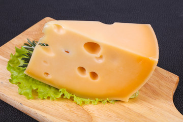 Maasdam cheese  in the board served salad leaves