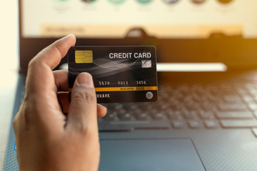 Mockup image of a hand holding credit card while using and typing on laptop.online shopping, online payment.