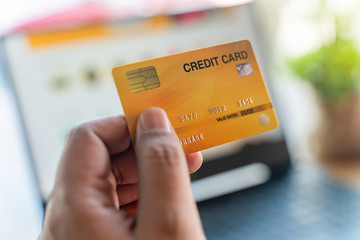 Man holding mock up credit card and laptop computer for online shopping.Online shopping, online payment,buy and sell products & services