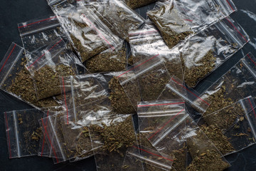 crime evidence: many packaged doses of cannabis lie on a dark surface