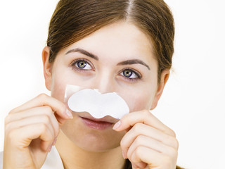 Woman applying pore strips on nose