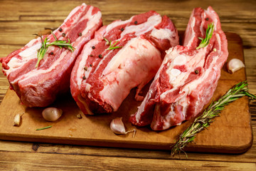 Raw pork ribs with spices, garlic and rosemary on wooden table