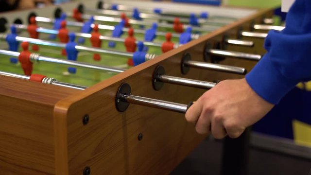 People playing foosball table soccer. Team sport, table football players. Competitive table game