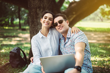 Couple young teen lover sitting and using laptop computer together at park,Romantic and enjoying in moment of happiness time,Happy and smiling