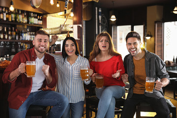 Group of friends watching football in sport bar