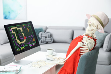 Human skeleton in red dress playing game at home