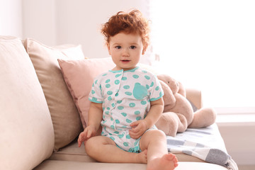 Portrait of cute little child on sofa at home