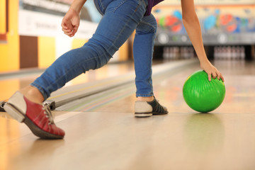 Fototapeta na wymiar Child throwing ball in bowling club, closeup