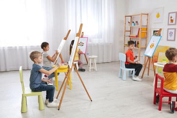 Cute little children painting during lesson in room