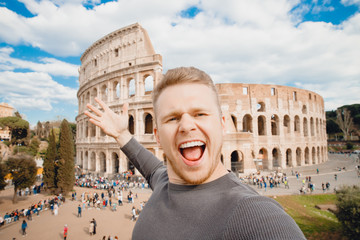 Happy young man making selfie and smile Colosseum in Rome, Italy. Concept travel