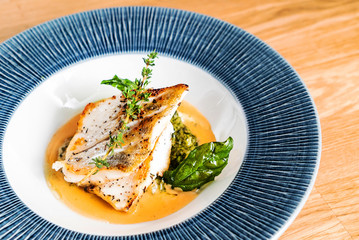 Fried fish fillet. Cod with sauce and herbs