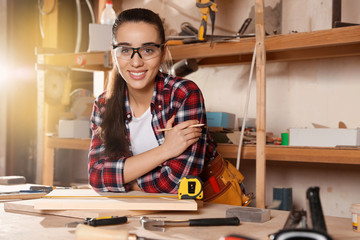 Female carpenter with wooden boards in workshop