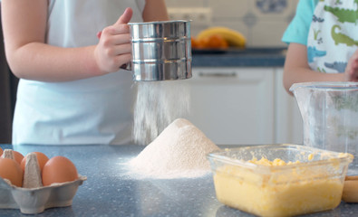 Hands of kids cooking cakes