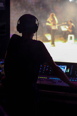 Musicians, operator and console on stage of a concert.