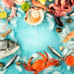 Fisch und Meeresfrüchte quadratischer Rahmen mit einem Platz für Text auf blauem Hintergrund. Goldbrasse. Garnelen, Krabben, Sardinen, Tintenfische, Muscheln, Kraken und Jakobsmuscheln, von oben geschossen © laplateresca
