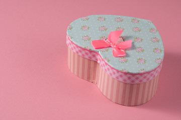 Valentine's Day celebration concept. A nice gift from a loved one. Box with a bow on a delicate pink background. Copy space. Flat lay. Close-up.
