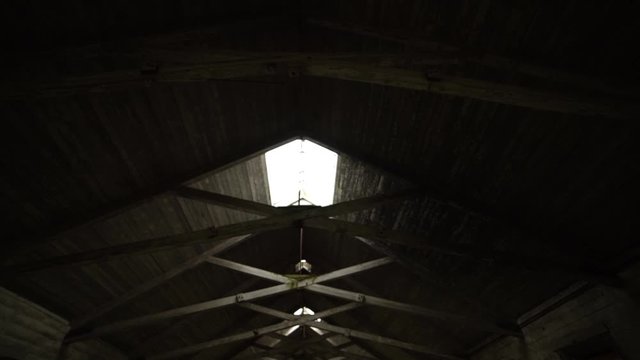 Interior pan down of an abandonded barn roof rafters near an insane asylum, dark, creepy, condemned