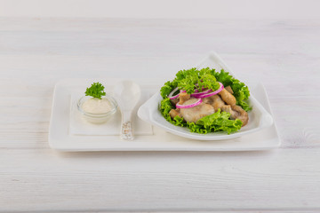salted mushrooms with onions and sour cream on white wooden background