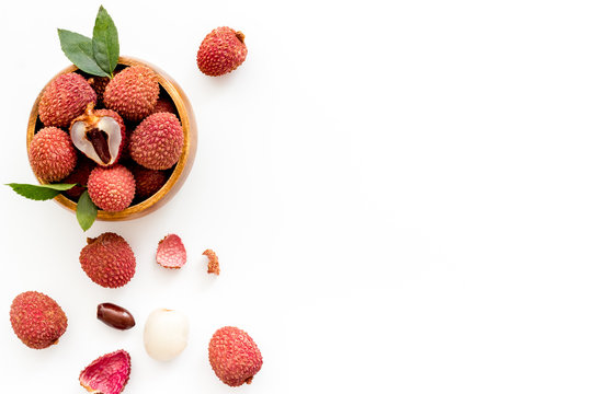 Fresh ripe lychee in bowl on white desk top-down frame copy space