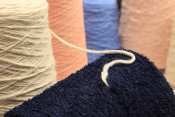 Fototapeta na wymiar Colorful yarn on spool at the knitting factory. Yarn on tube, cotton, wool, linen thread.
