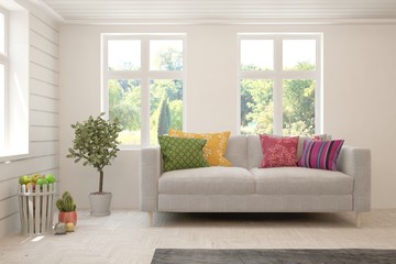 Stylish room in white color with sofa and summer landscape in window. Scandinavian interior design. 3D illustration
