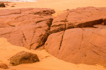 Fototapeta premium Beach Sand and Large Rocks Line the Seashore