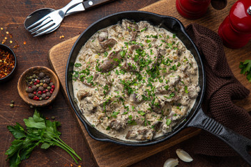 fried chicken liver with creame sauce on black cast iron pan