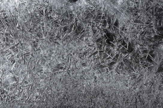 Beautiful white frozen ice crystals, crack texture on black background, winter seasonal backdrop