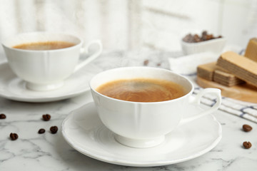 Delicious coffee and wafers for breakfast on white marble table