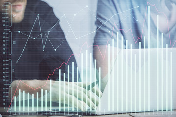 Forex graph with businessman typing on computer in office on background. Concept of analysis. Double exposure.