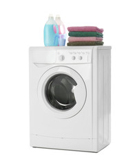 Modern washing machine, stack of towels and detergents on white background. Laundry day