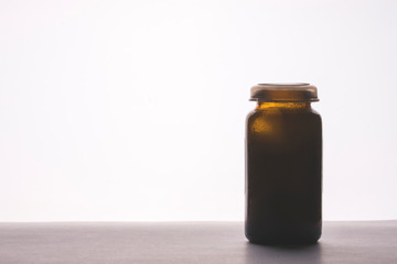 glass bottle of medicine on the table, tinting, selective focus, space for text on the left, white background