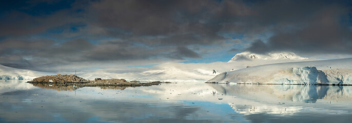 wide panorama with view to polar station on island and glacier in Antarctica