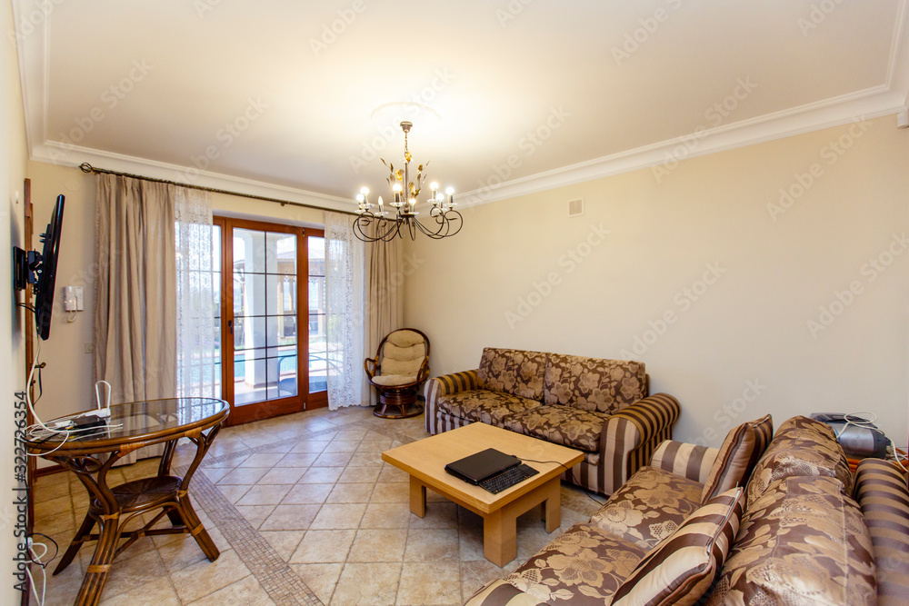 Wall mural luxury room in beige tones in a classic style with two brown-striped sofas and a coffee table