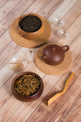 Chinese Ceremony. Brown clay pot and glass cups. Red tea in wooden bowls on aged wooden