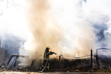 Firefighters extinguish a fire in forest by water flooding