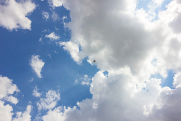 A light aircraft flying under the clouds