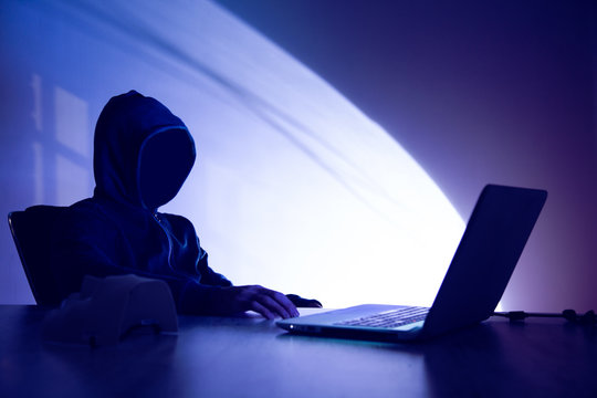 man hacker with computer on dark background