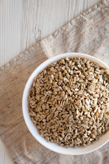 Raw Sunflower Seed Kernels in a white bowl, overhead view. Flat lay, top view, from above.