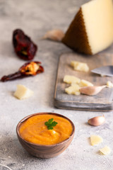 Famous La Gomera  paste or sauce Almogrote  in wooden bowl  with  ingredients .hard goat cheese, peppers, olive oil and garlic on light concrete background..