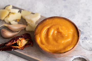 Almogrote , cheese paste form La Gomera, Canary Islands in wooden bowl on cut board with hard goat cheese, peppers  and garlic.Close up