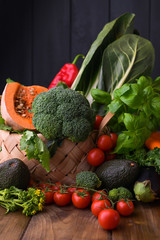 Harvest. Food or Healthy diet concept. Big Basket with different Fresh Farm Vegetables, pumpkin, broccoli, chard, avocado and tomatoes. Copy space. Selective focus. Top view