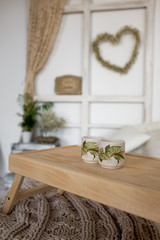 Two cups on wooden trey in bedroom. room in a modern Scandinavian style. 