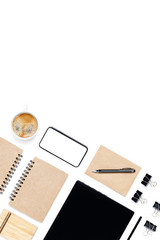 Workspace with laptop, smartphone, pen, document clips, notepads and cup of coffee on isolated white background. Top view with copy space.
